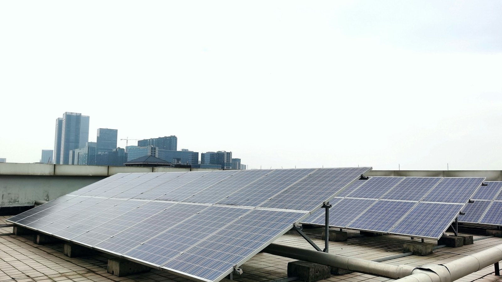 Susunan panel solar atas bumbung dengan latar langit bandar &mdash; ilustrasi penerimaan solar kediaman di bawah SuRIA Home